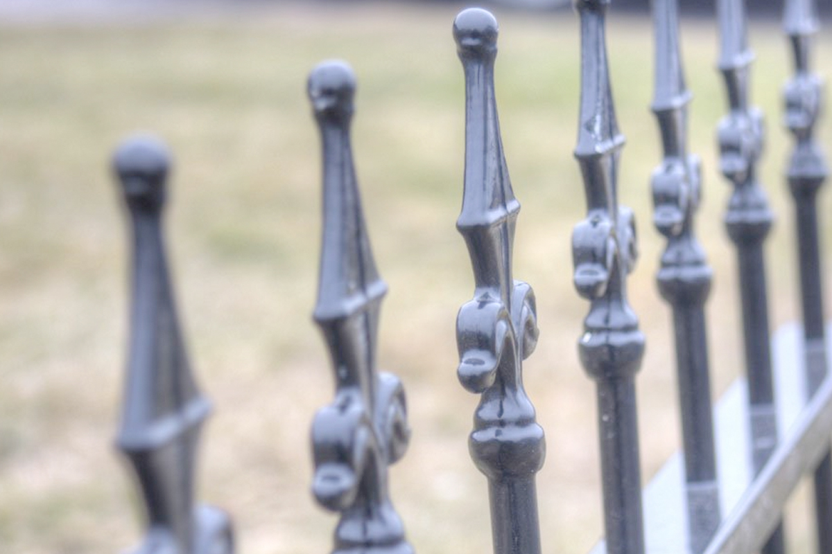 Klassieke charme met een tuinhek met gietijzeren hekpunten en paalkoppen